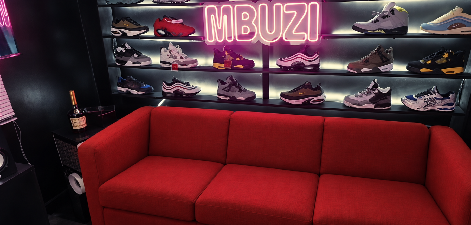 Mbuzi Studios red sofa and neon sneaker wall